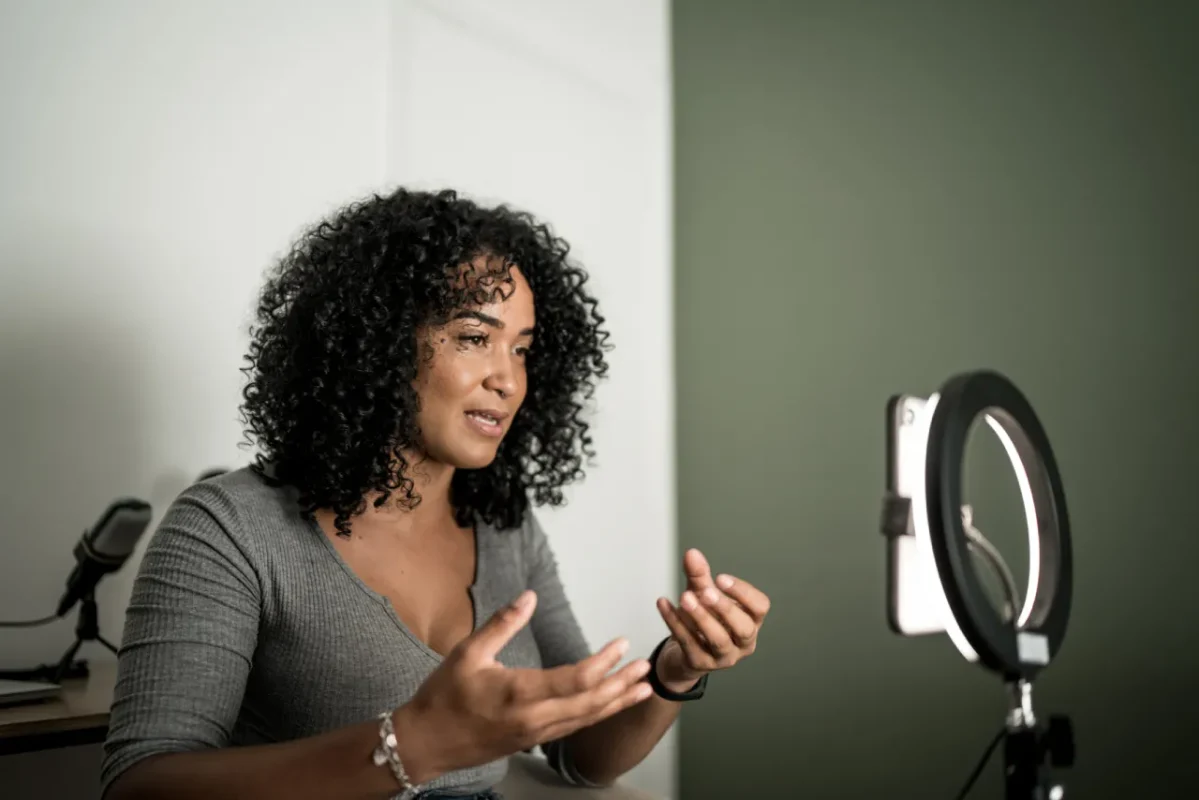 Trépied anneau lumineux qui éclaire une femme parlant à son iphone